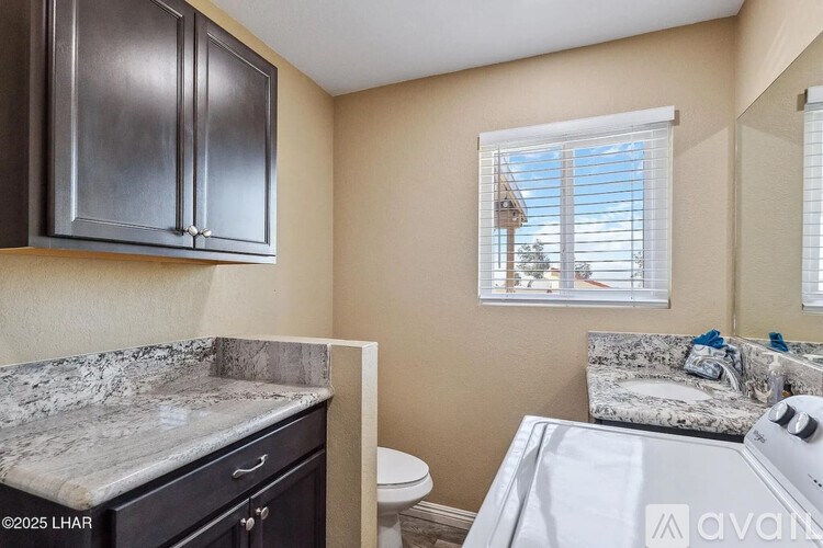 A kitchen with dark cabinets and a marble countertop.