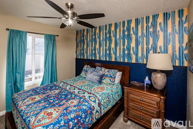 A bedroom with a bed, nightstand, and a ceiling fan.
