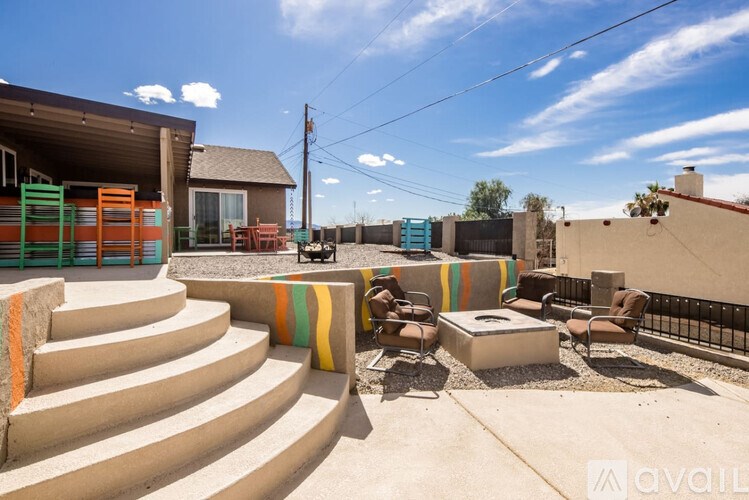 A patio with a table and chairs is surrounded by a black fence.