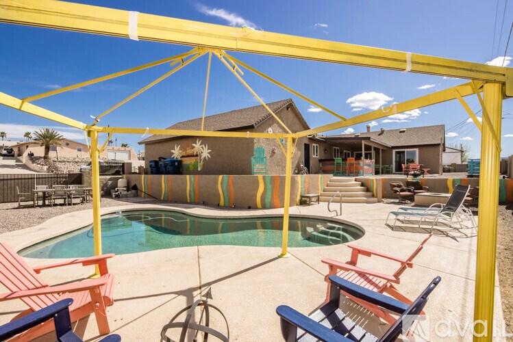 A pool area with a yellow canopy and multiple chairs.