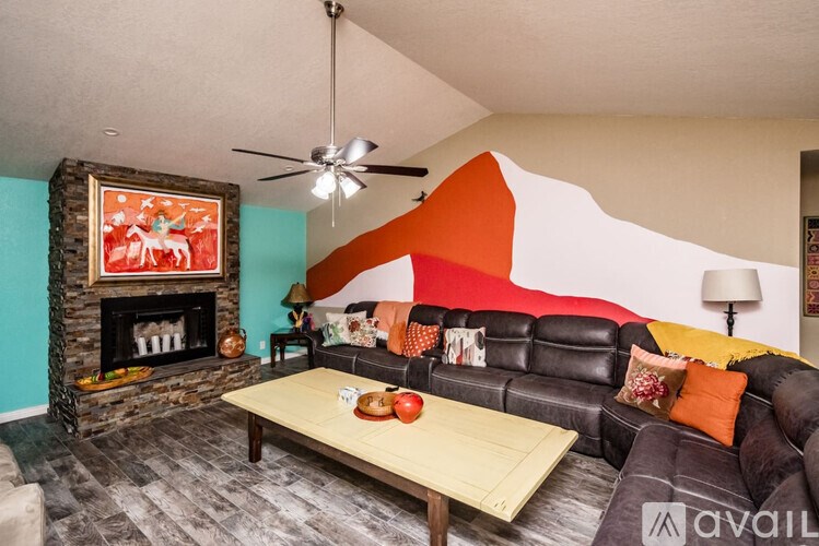 A living room with a fireplace and a painting on the wall.