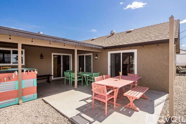 A patio with a table and chairs is set up outside a house.