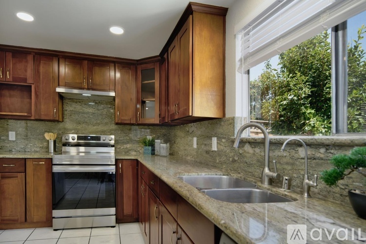 A kitchen with wooden cabinets and a stainless steel oven.