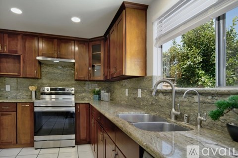 A kitchen with wooden cabinets and a stainless steel oven.