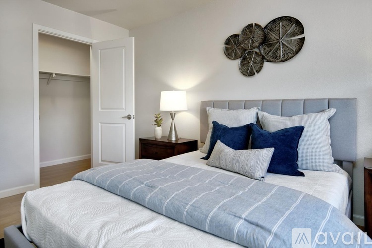 A bedroom with a large bed and a wall decoration.