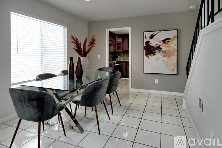 A dining room with a glass table and chairs.