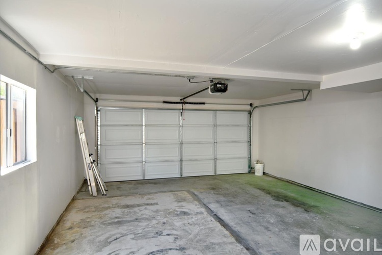 A spacious garage with a white door and a ladder.