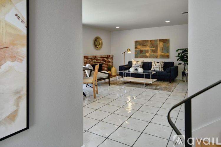 A living room with a brick wall and a painting on the wall.