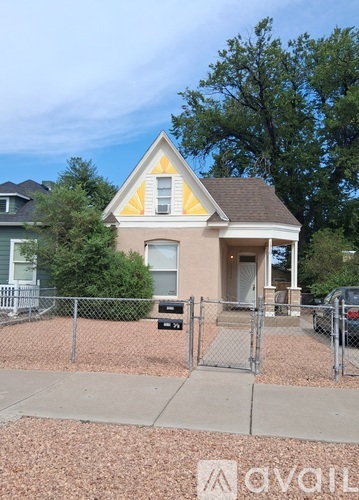 A small house with a fence in front of it.