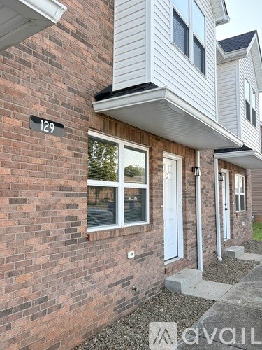 A house numbered 129 with a white door and windows.