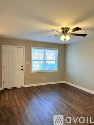 A room with a ceiling fan and a window.