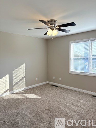 A room with a ceiling fan and a window.
