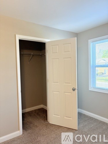 A room with a white door and a window with blinds.