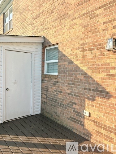 A white door is on the left side of a brick wall.