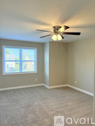 A room with a ceiling fan and a window.
