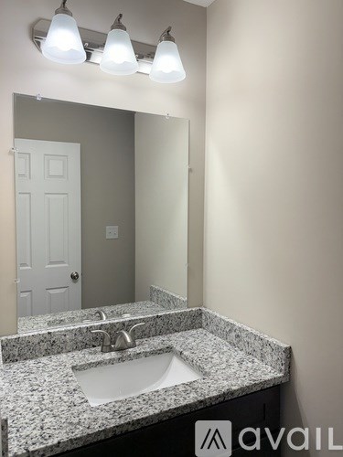 A bathroom with a granite countertop and a white sink.