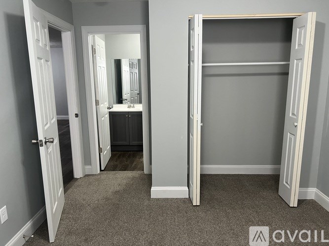 A room with a white door and a grey wall.