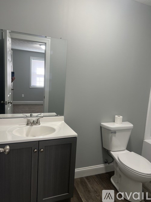 A bathroom with a toilet, sink, and medicine cabinet.