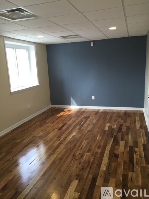 A room with wooden flooring and a window.