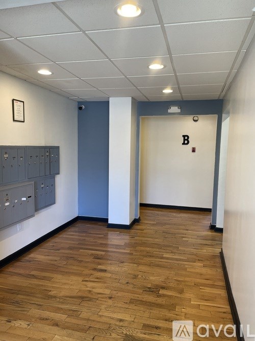 A hallway with a blue door and a white door with a letter B on it.