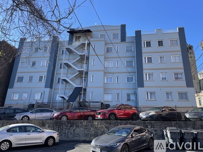 A grey building with a red car in front of it.