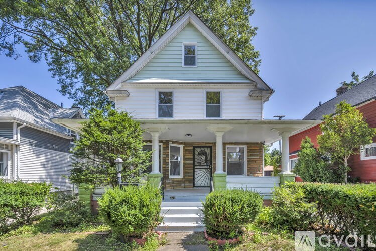 A white house with a green front yard.