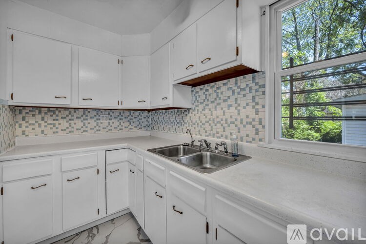 A kitchen with white cabinets and a tiled backsplash.