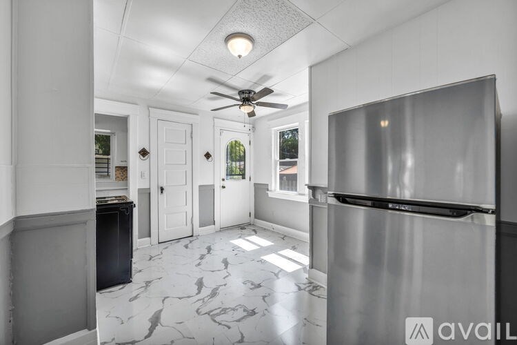 A kitchen with a marble floor and a stainless steel refrigerator.