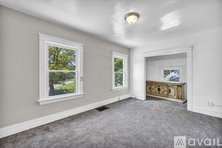 A room with a window and a painting on the wall.