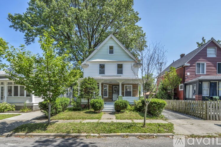 A house with a white front porch and a green lawn.