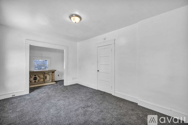 A room with a grey carpet and white walls.