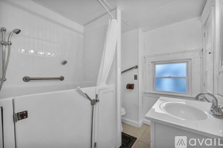 A bathroom with a white tub, sink, and toilet.