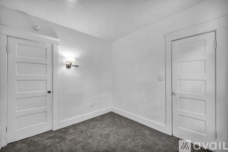 A room with two doors and a carpeted floor.