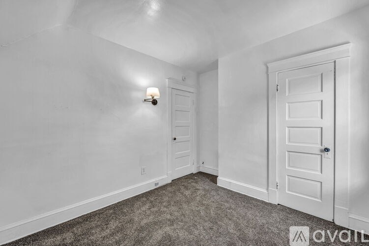 A room with a carpeted floor and a white door.