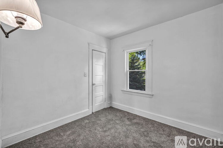 A room with a window and a door is available for rent.