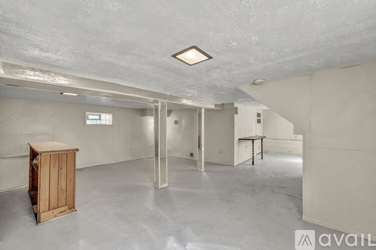 A large empty room with a wooden box on the floor.