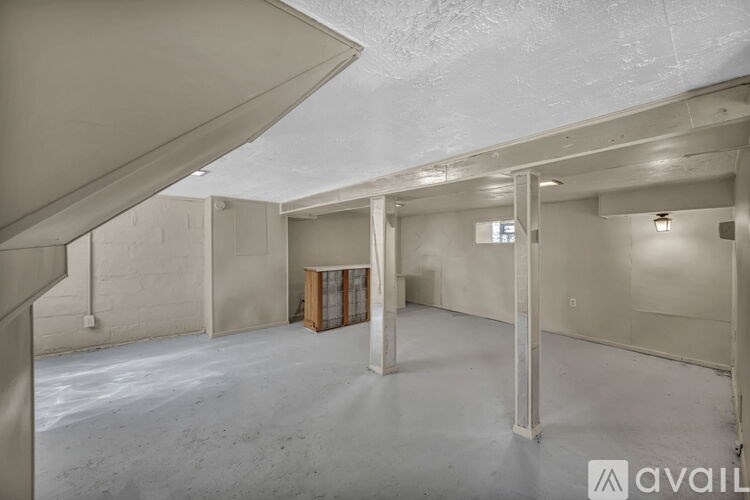A spacious, empty room with a concrete floor and white walls.