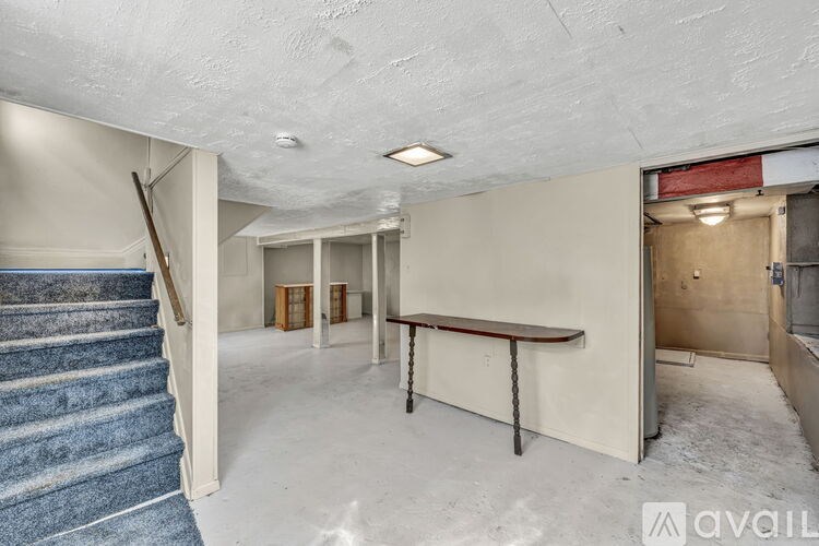 A room with a staircase and a table in it.
