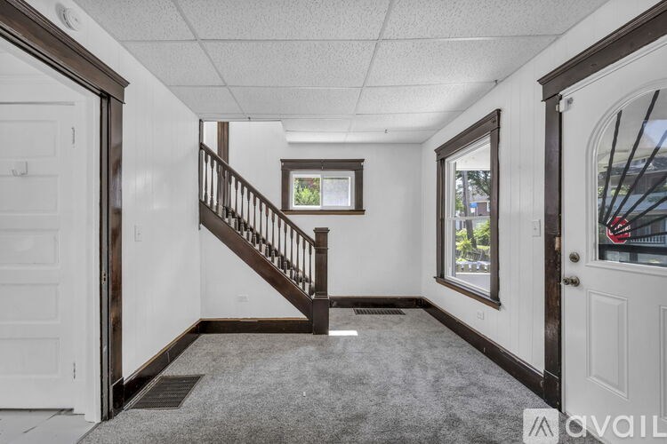 A hallway with a staircase and a window.