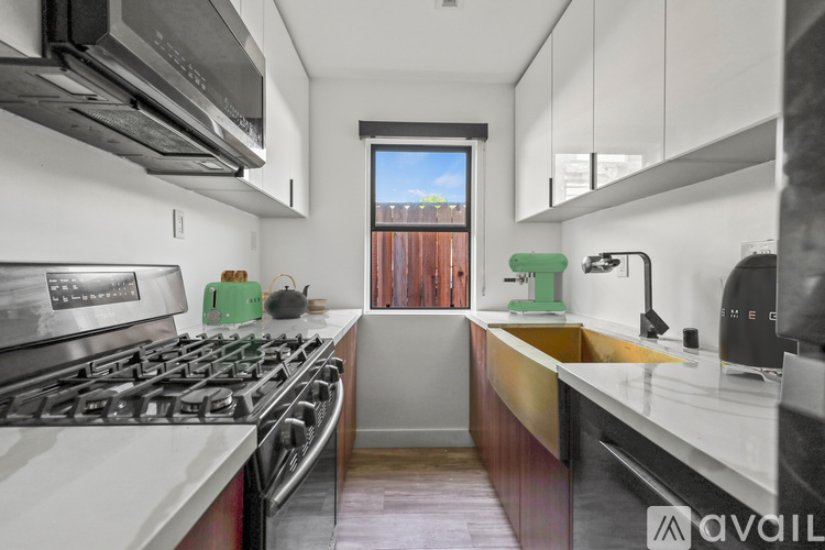 A modern kitchen with a stove top oven and a window.