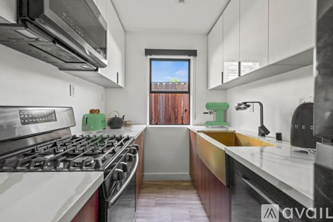 A modern kitchen with a stove top oven and a window.