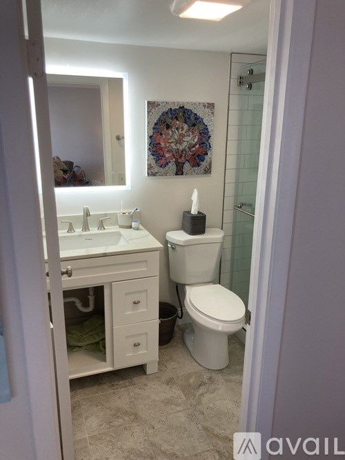 A bathroom with a toilet, sink, and mirror.