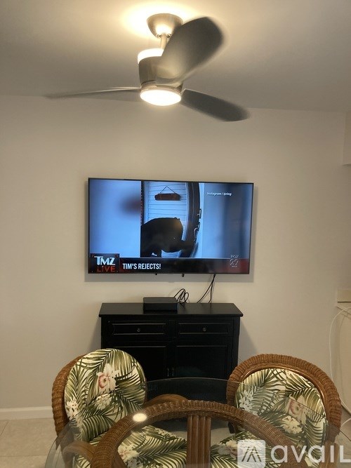 A television screen shows a man in a black suit.