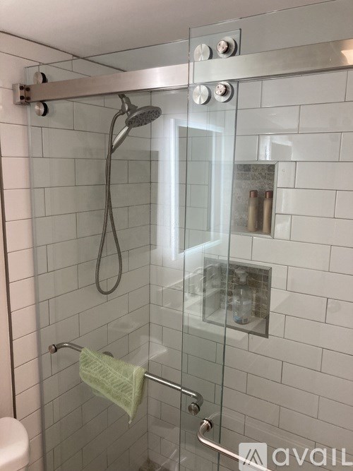 A glass shower door with a towel hanging on the handle.