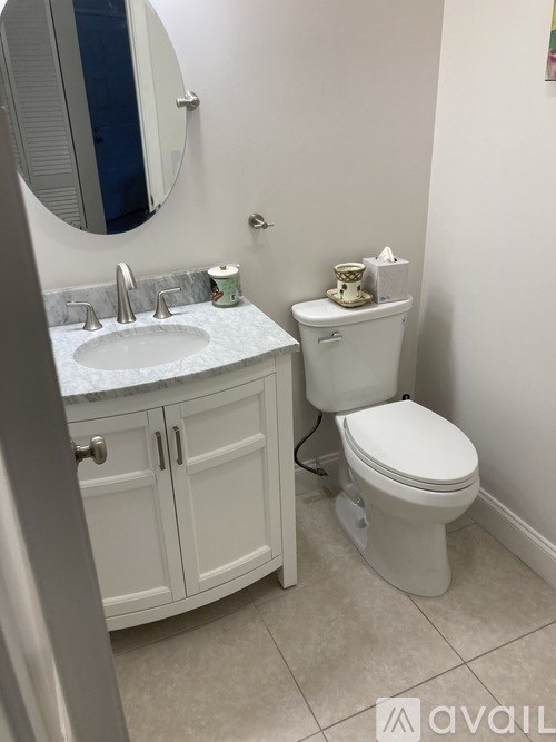 A white toilet sits next to a sink in a bathroom.