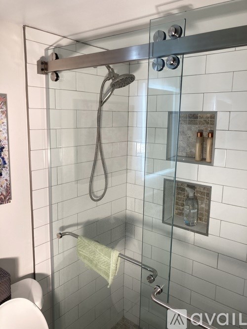 A white toilet is next to a glass shower door.