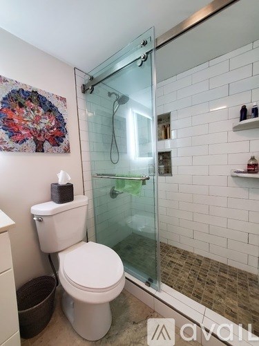 A white toilet sits next to a glass shower door in a bathroom.