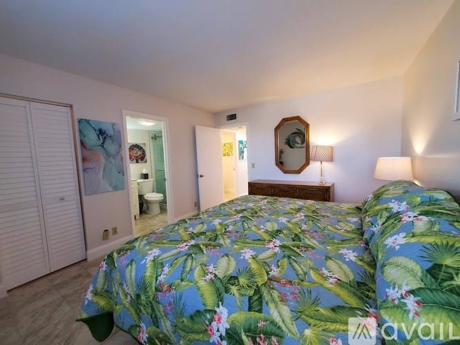 A bedroom with a bed covered in a floral print bedspread.