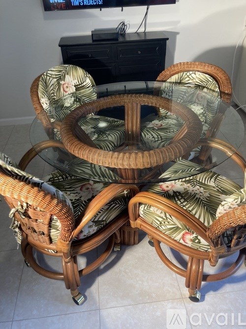 A set of three wicker chairs with floral cushions.