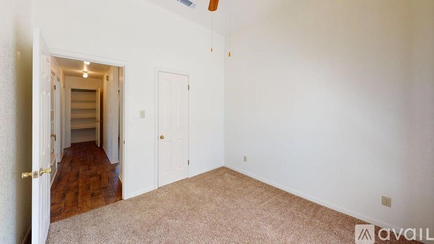 A room with a carpeted floor and a doorway leading to another room.